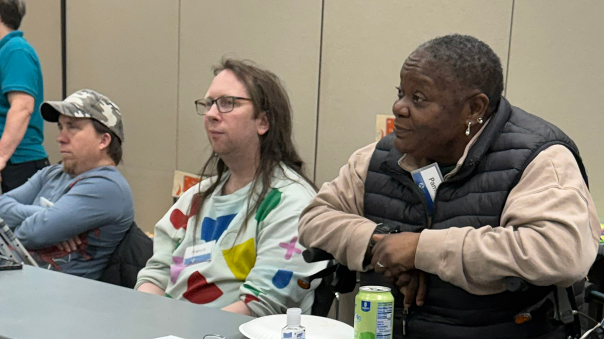 Three people watching a presentation offscreen