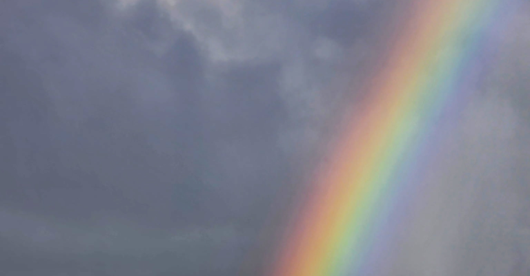 A rainbow against a dark cloudy sky