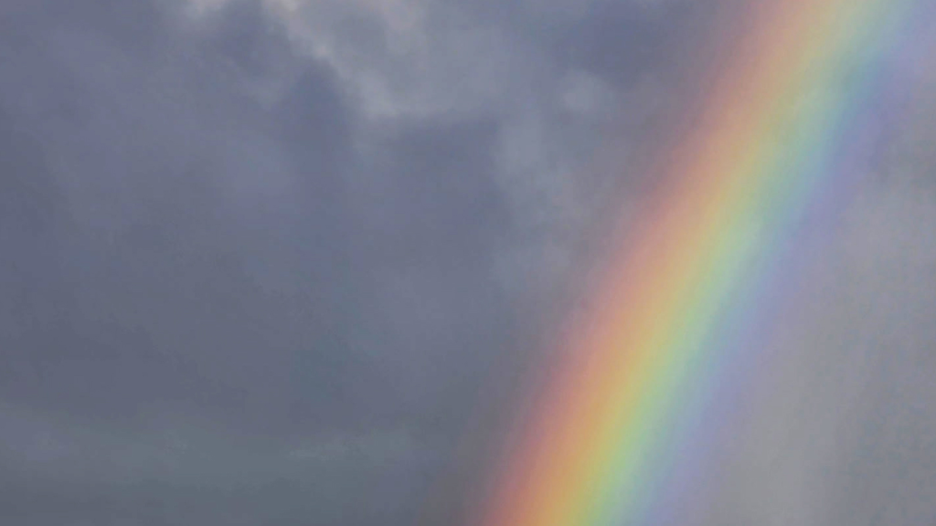 A rainbow against a dark cloudy sky