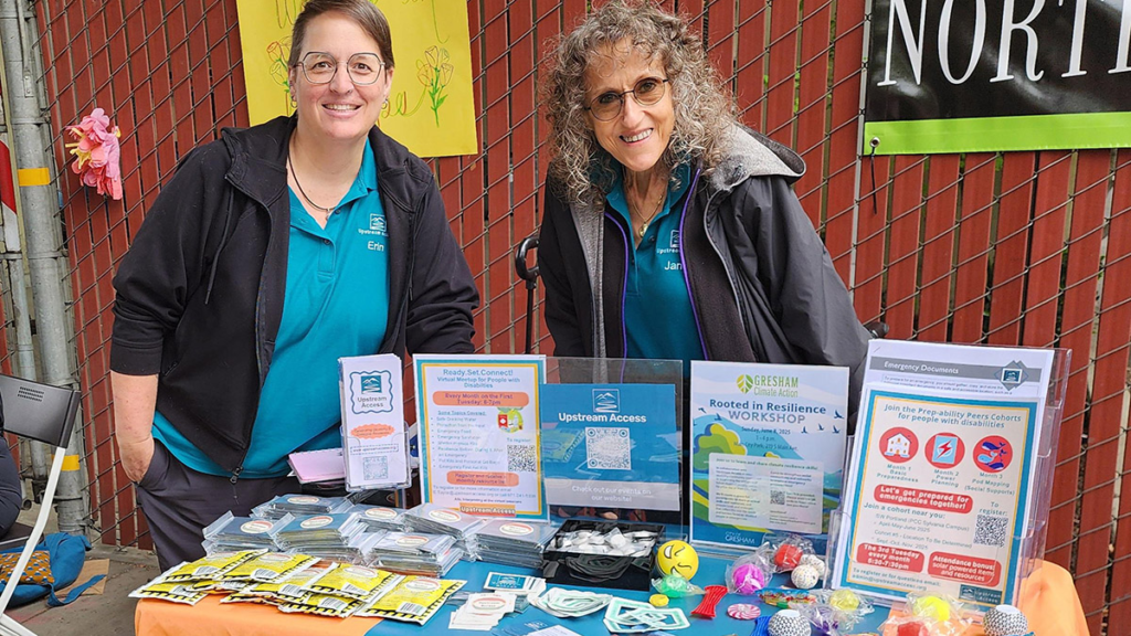 Two people standing behind a table covered in information materials